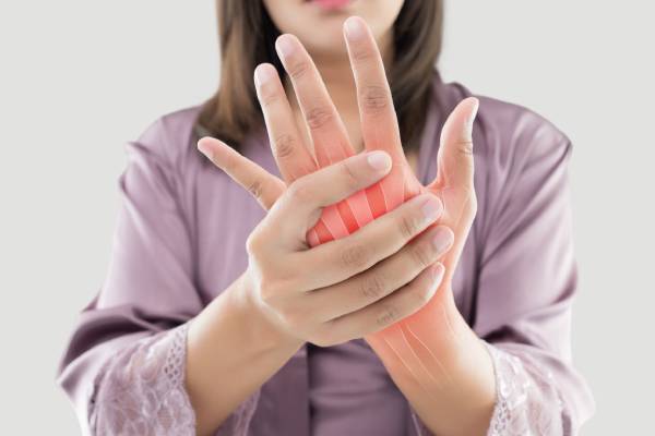 Woman holding painful hand joint – Arthritis Treatment in PCMC Pune