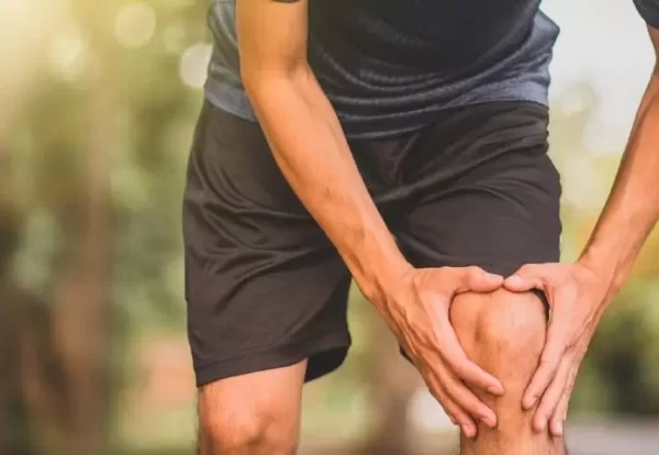 Young man holding knee due to Joint Pain in Young Adults – Dr. Ashutosh Jadhav, Best Orthopedic Doctor in PCMC, Pune