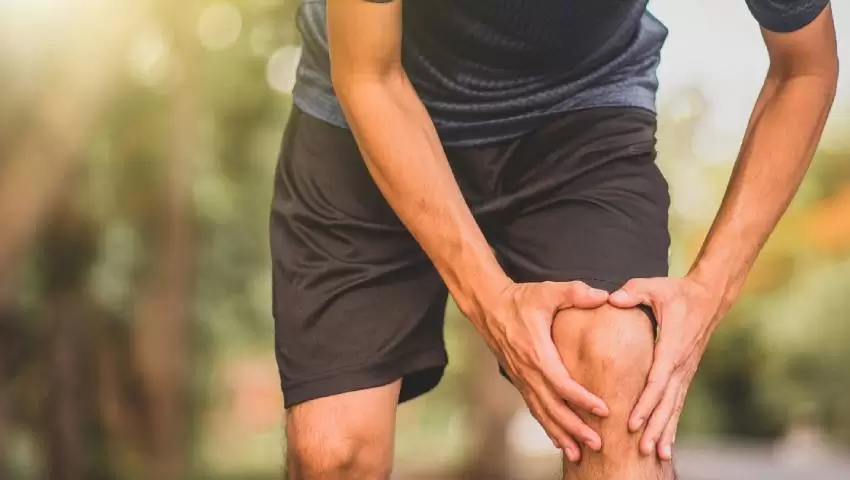 Young man holding knee due to Joint Pain in Young Adults – Dr. Ashutosh Jadhav, Best Orthopedic Doctor in PCMC, Pune