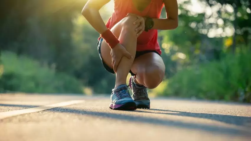 Runner holding leg due to sports injury – Managing Sports Injuries at Home with expert advice from Dr. Ashutosh Jadhav, Orthopedic Doctor in PCMC, Pune